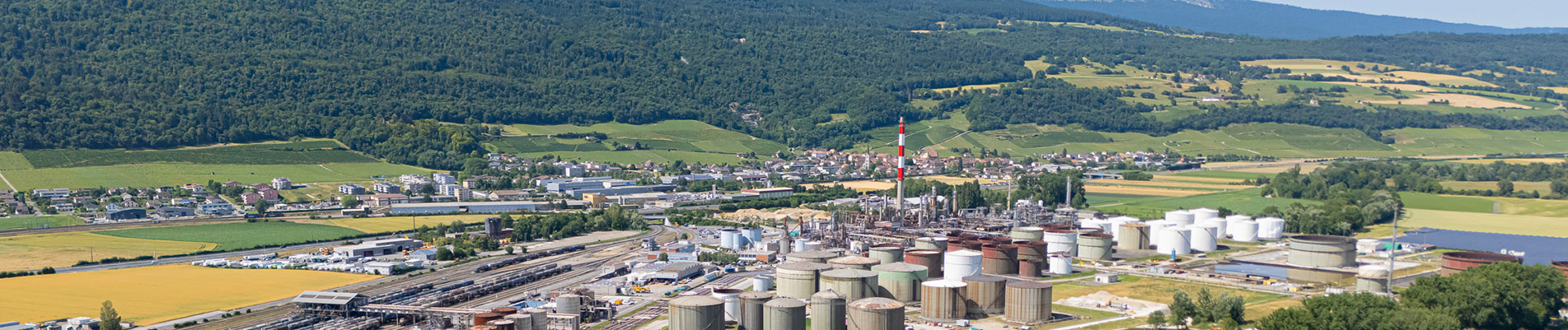 Varo's Cressier refinery with hills behind it and river