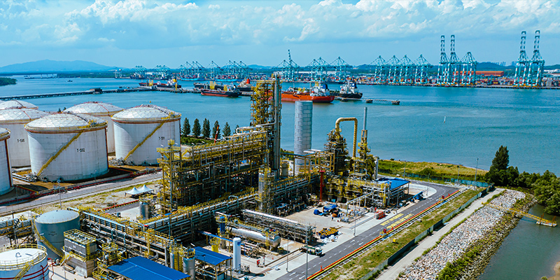 Processing unit/refinery with vessels and port cranes in background