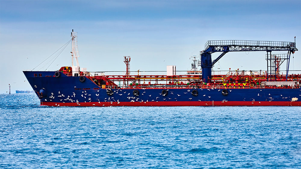 bunker barge at sea with flock of birds at flight